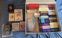 Full view of the assortment of tarot and oracle card decks and books laid out with a decorative object.