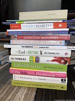 Stack of health and diet-related books showing titles and authors, mostly medical and wellness focused.