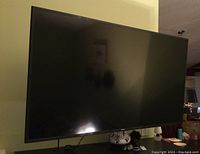 Front view of 58-inch TV powered off on console