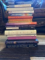 Stack of self help books showing spines with titles and authors.