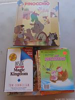 Photo showing Pinocchio hardcover storybook, Inside the Magic Kingdom book by Tom Connellan, and The Rescuers storybook.