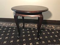 Full view of the round side table showing the shape, legs, and finish.