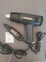 Mastercraft heat gun and Dremel moto-tool seen lying on floor with cords neatly coiled
