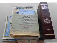 Pile of National Geographic maps on table with storage binder case on right side