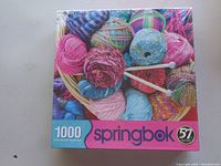 Photo of shrink-wrapped Springbok 1000-piece puzzle box with yarn basket image and size details