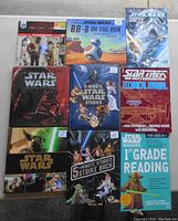 Front view of 14 Star Wars and Star Trek related books arranged in grid showing covers and titles. Includes storybooks, workbooks, and technical manual.