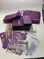 Full overview of all Jamberry nail kit contents including mini heater, multiple nail wraps, wooden cuticle sticks, nail files, metal nail clippers, and two purple cosmetic bags showing one with broken zipper.