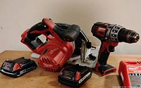 Group shot showing saw, drill, two batteries and charger