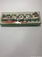 Top view of packaged wooden Christmas candle train set with four train sections and candles inside plastic window box.