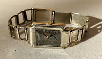 Front angle of the Tavannes Art Deco wristwatch with silver-tone case and tarnished silver face.