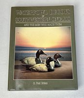 Front cover of the hardcover book titled 'Waterfowl Decoys of Southwestern Ontario and the Men Who Made Them' featuring an image of three duck decoys against a sunset background.