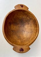 Top view of vintage wooden bowl showing the heart design on both handles.
