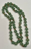 Full view of green jade bead necklace on white background