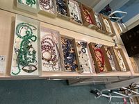 Overview of multiple trays with assorted necklaces, bracelets, earrings and pins