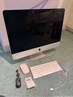 Front view of iMac, wired keyboard and both mice arranged below screen