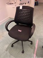 Side angle view showing the chair's padded seat, armrests, and caster wheels.