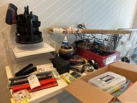 Full view of office supplies lot including black rotating desk organizer, hole punch, assorted clips, folder, and craft tools, with some items still in packaging.