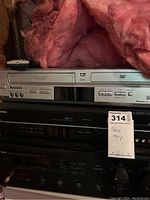 Panasonic Omnivision DVD player with control buttons and input jacks visible, located above other equipment.