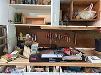 Overview of tools and hardware on workbench including towel bar box, screwdrivers, storage organizer, and WD40