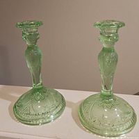 Pair of green Indiana Glass candlesticks with Tiara pattern shown front view