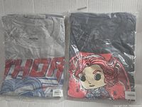 Two Marvel Funko T-Shirts in packaging, one gray with Thor text, one black with Black Widow Funko Pop graphic.