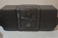 Full front view of the JVC PC-X55 boombox showing dual speakers and central control unit.