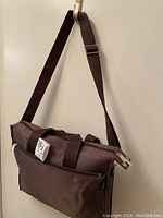 Front view of brown cross body nylon Milano shoulder bag showing adjustable wide strap and front zipper pocket