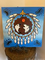 Full front image of the Woodlands style painting showing the dreamcatcher with bison and buffalo heads and feather details with blue background.