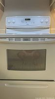 Front view of white Kenmore electric stove showing control panel and oven door