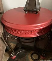 Side view showing the detailed carved edge of the tabletop and metal curved legs with decorative foot caps.