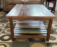 Front view of rustic large coffee table showing wood grain top and multi-colored bottom shelf.