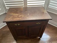 Full view of antique washstand showing worn wood top and overall construction.