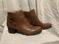 Brown leather ankle boots with side zippers shown from side angle