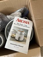 Instruction manual for Aroma 7-cup rice cooker and food steamer showing cover with image of the appliance.