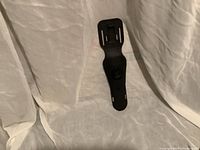 Photo of black plastic holder for underwater safety cutter, disconnected from any straps, with visible wear.