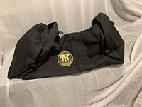 Black Poseidon duffel bag with logo visible, showing its shape and material.