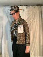 Image showing a dressed mannequin wearing leopard print fleece jacket, leopard print camisole, black skirt, leopard print hat, and rhinestone black frame glasses without lenses, with ID badge hanging.