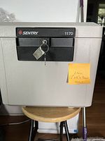 Photo of the Sentry portable safe showing front view with two keys in lock and sticky note detailing keys, dimensions, and weight.