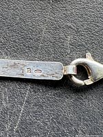 Close-up photo of the sterling silver hallmark '925' on a flat segment near lobster clasp.