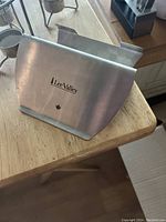 Stainless steel Lee Valley cookbook holder with logo and a small maple leaf cutout on one side.