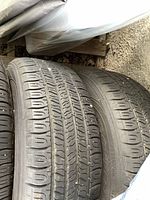 Close-up of tire tread showing wear and dirt. Various tread design visible.