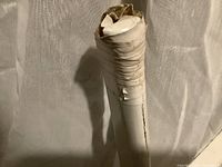 Close-up of damaged white plastic extension part of Holmes window fan showing cracks and wear.