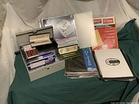 Overview photo showing the petty cash box, receipt books, report folders in clear and black, alphabetical tab dividers, printable tear-off tickets, and sheets with stick-on letters and numbers.