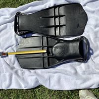 Photo of two black Rocket diving fins laid flat on white cloth showing top and bottom sides with a measurement tape for length approximate 10 inches.