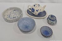 Full set of six blue and white ceramic dishes including teapot with tray, 5 bowls/dishes of various shapes and patterns.