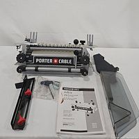 Front view of Porter Cable dovetail jig with accessories and manual laid out.