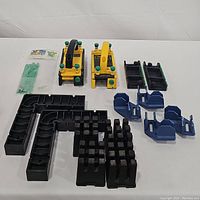 Photo displaying all items including push blocks, K body clamps, black corner clamps, and blue corner clamps arranged on a white surface.