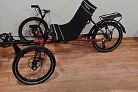 Side view showing red frame, two front wheels and seat position