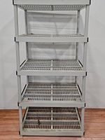 Front view of the white 5-tier plastic shelving unit showing all shelves and structure.