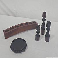 Set of all wooden candle holders shown on white background: three turned candlesticks, curved slot holder, and round footed holder.